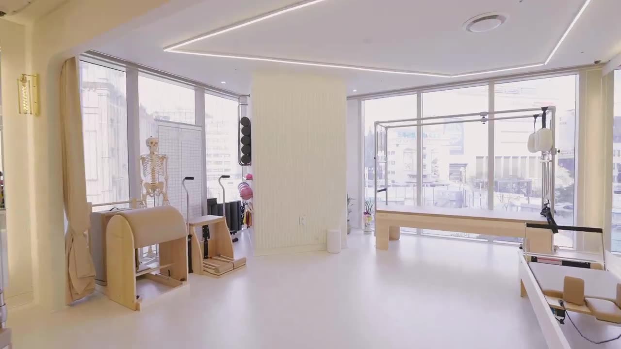 창이 넓은 RU PILATES 스튜디오 내부. 리포머와 래더배럴 등 필라테스 기구가 놓여 있다.